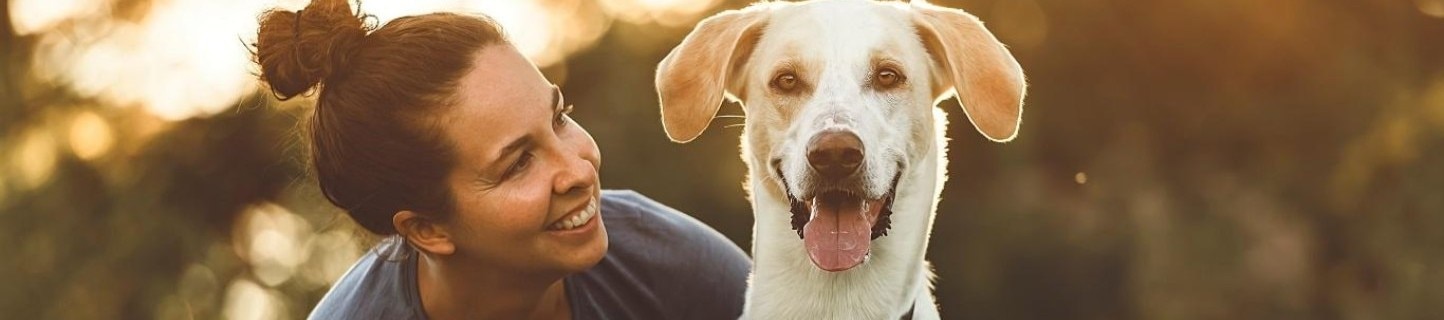 A woman smiling with a dog.