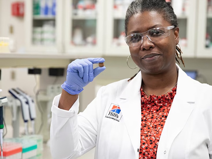 a scientist holding Hill's Pet dog food in her hand